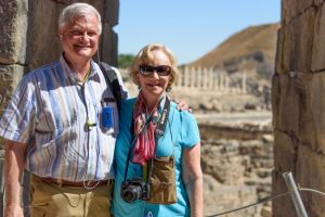 Ruth and Philip smile next to each other posing for a picture outside in front of an old middle eastern building 